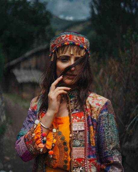 a woman wearing a jacket and a colorful dress
