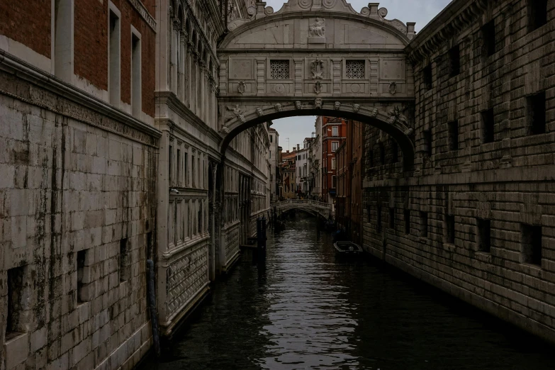 a small boat moving down a canal between two buildings