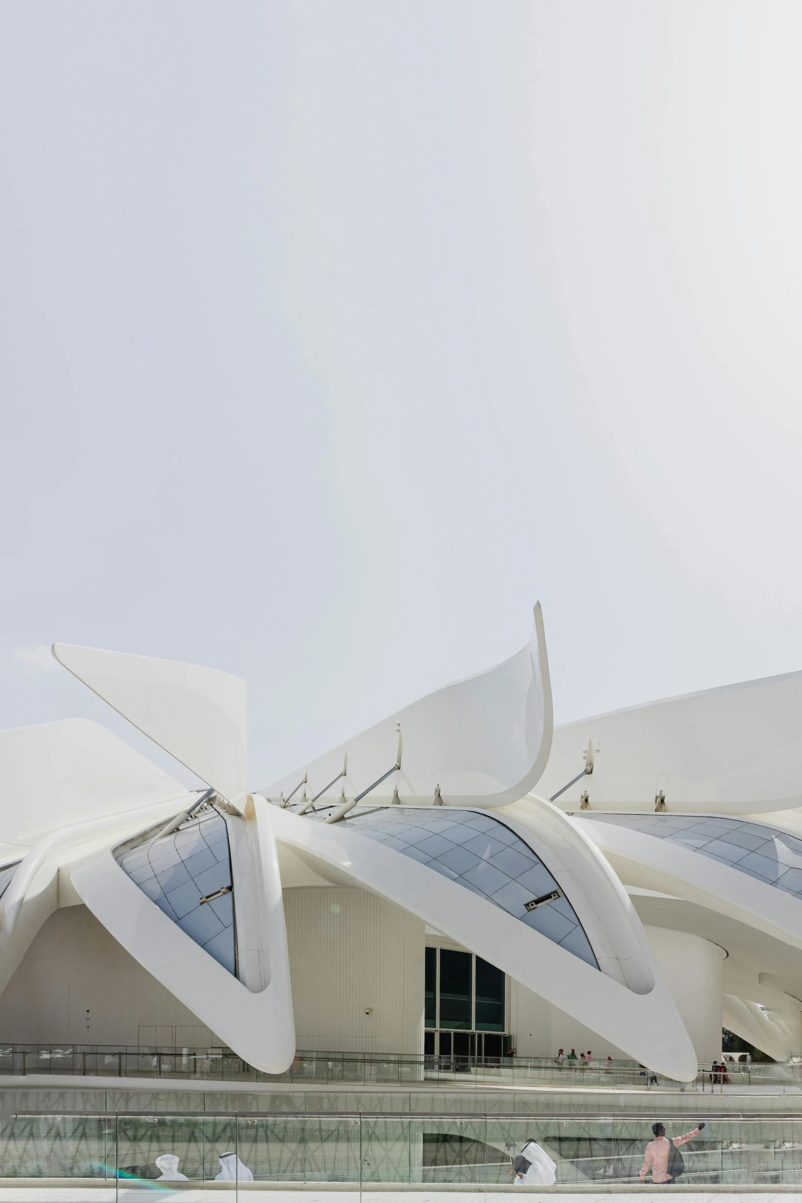 a huge building with curved white walls under a blue sky