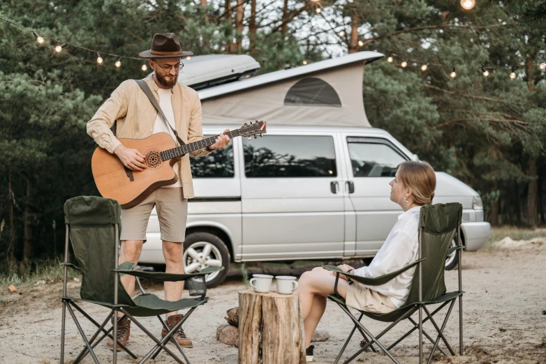 the man is playing guitar near the little girl