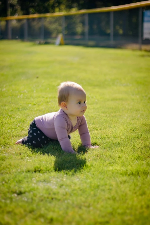 a baby crawling down on the grass