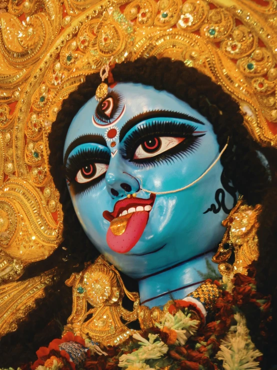 a close up of the face of a mask, decorated with gold and green accents