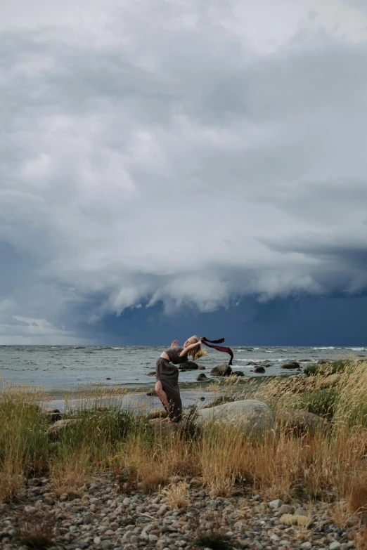 there is a man holding soing up near the water