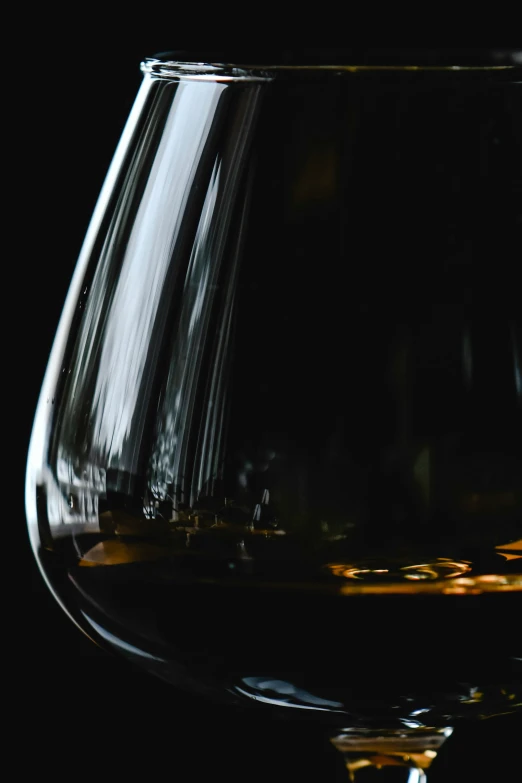 close up s of a black wine glass with black wine in the bottom