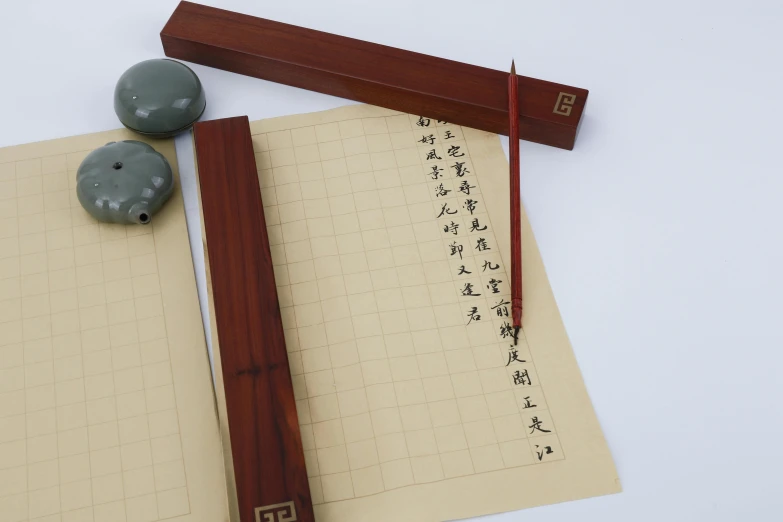 a note pad that has an oriental writing tool on it