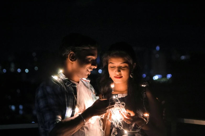 a couple standing next to each other with a candle