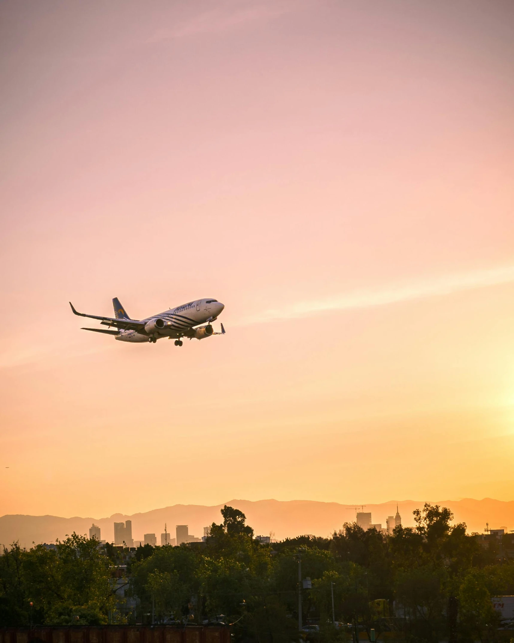 an airplane is taking off into the sunset