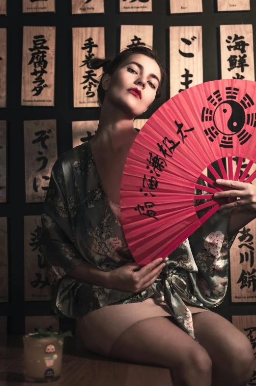 a woman holding a red umbrella and oriental writing