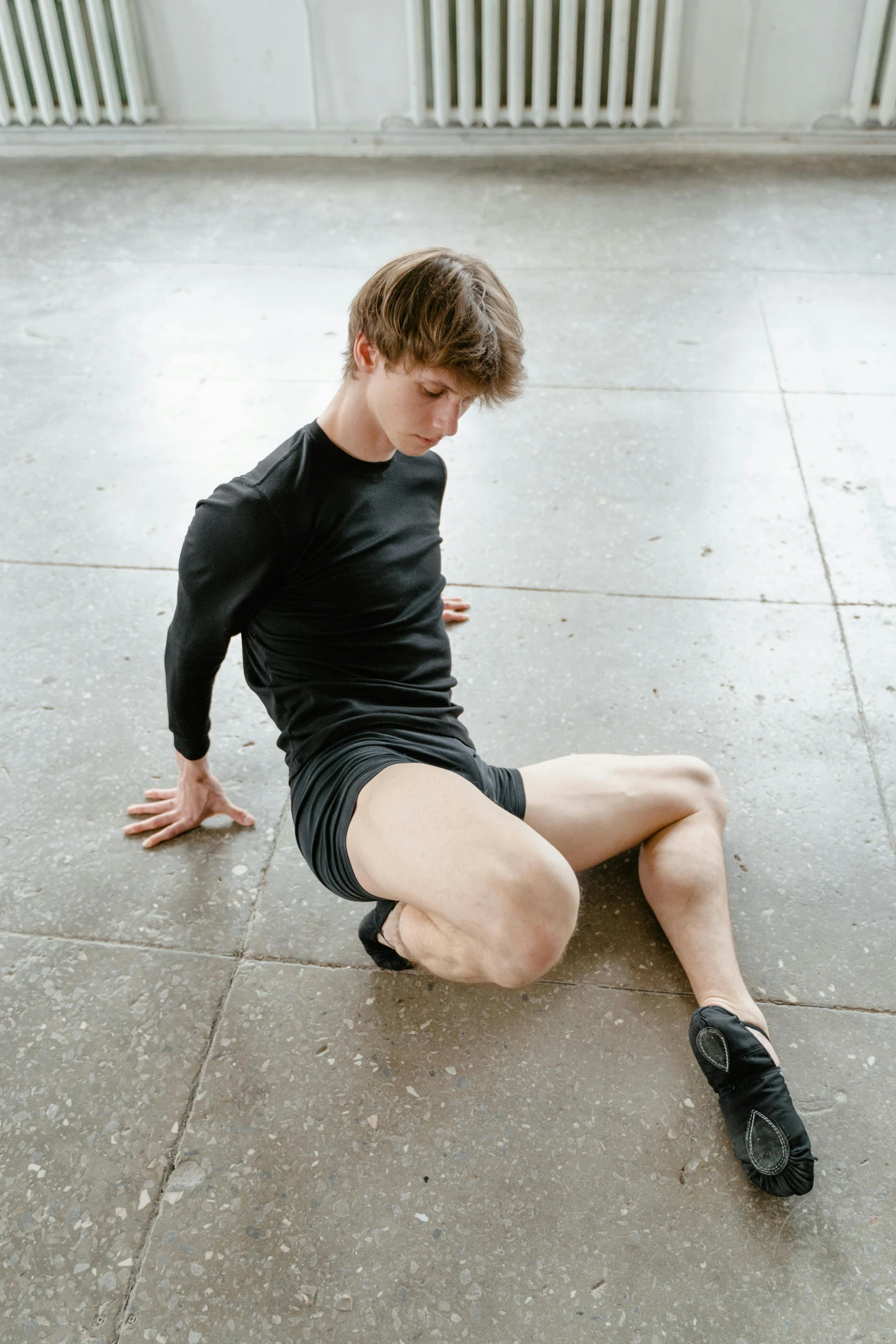 the young man is sitting down with his feet on the ground