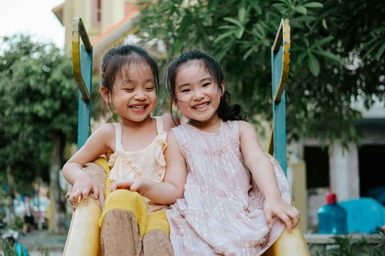 two small girls sit together on a ride