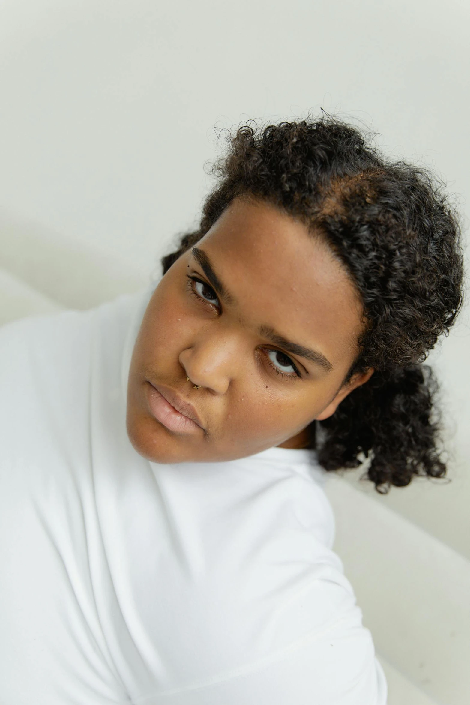 woman with short curly hair wearing a white shirt