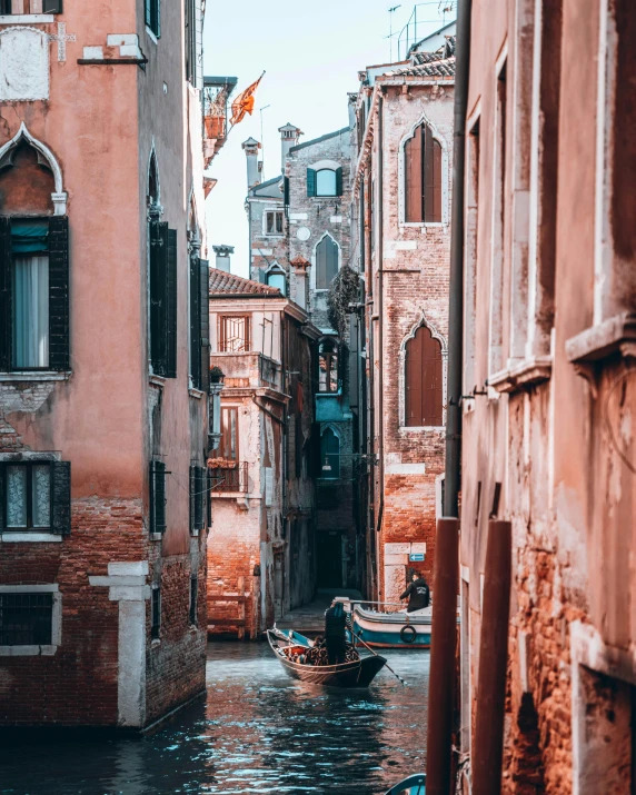 a boat traveling down the side of a river in a city