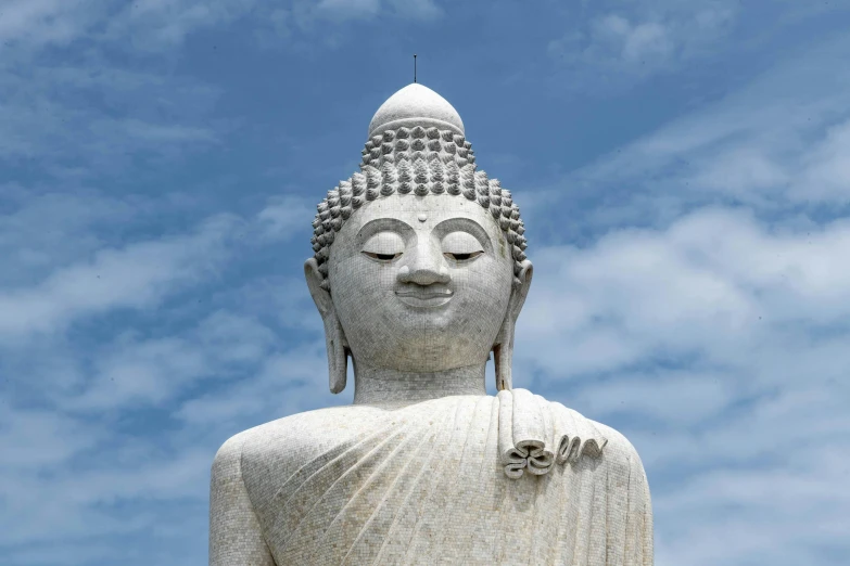 a tall buddha statue with a sky background