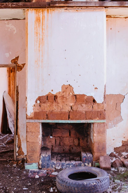 an old fireplace in an abandoned building next to a tire