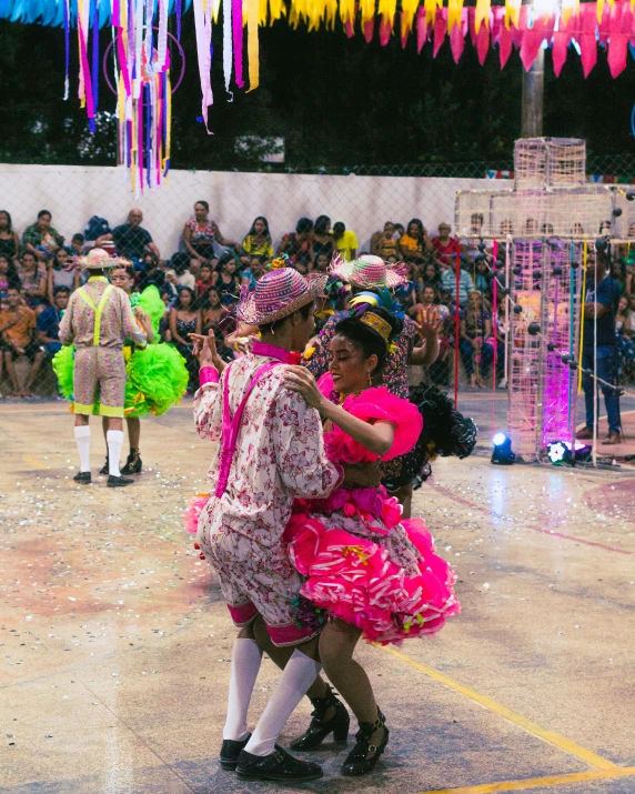 two women are dancing in a street festival