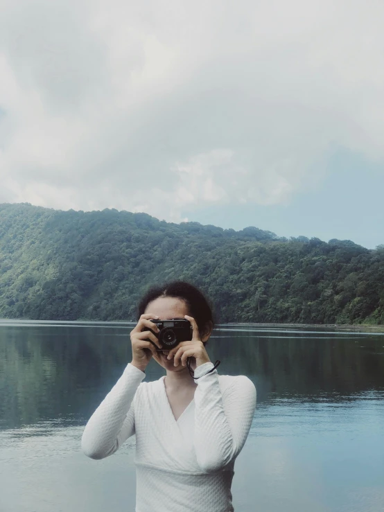 woman takes a po of herself in front of a body of water