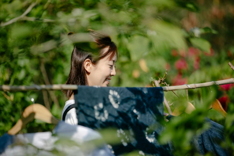 a woman standing next to bushes and looking at soing