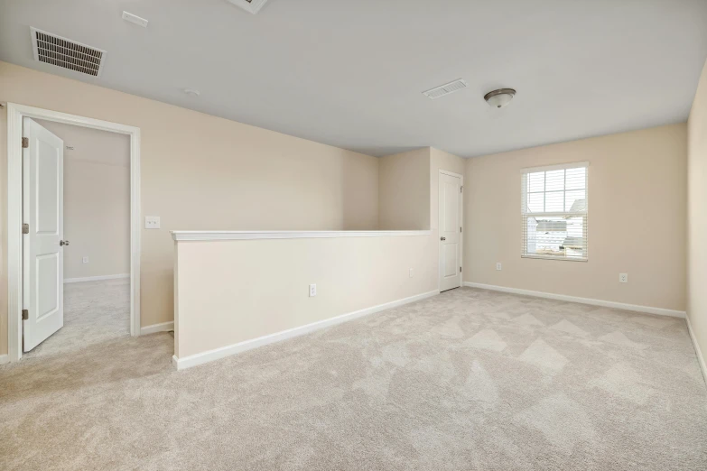 an empty living room with carpeting and beige walls