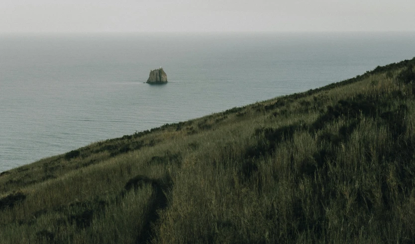 a lone rock sticking out of the ocean