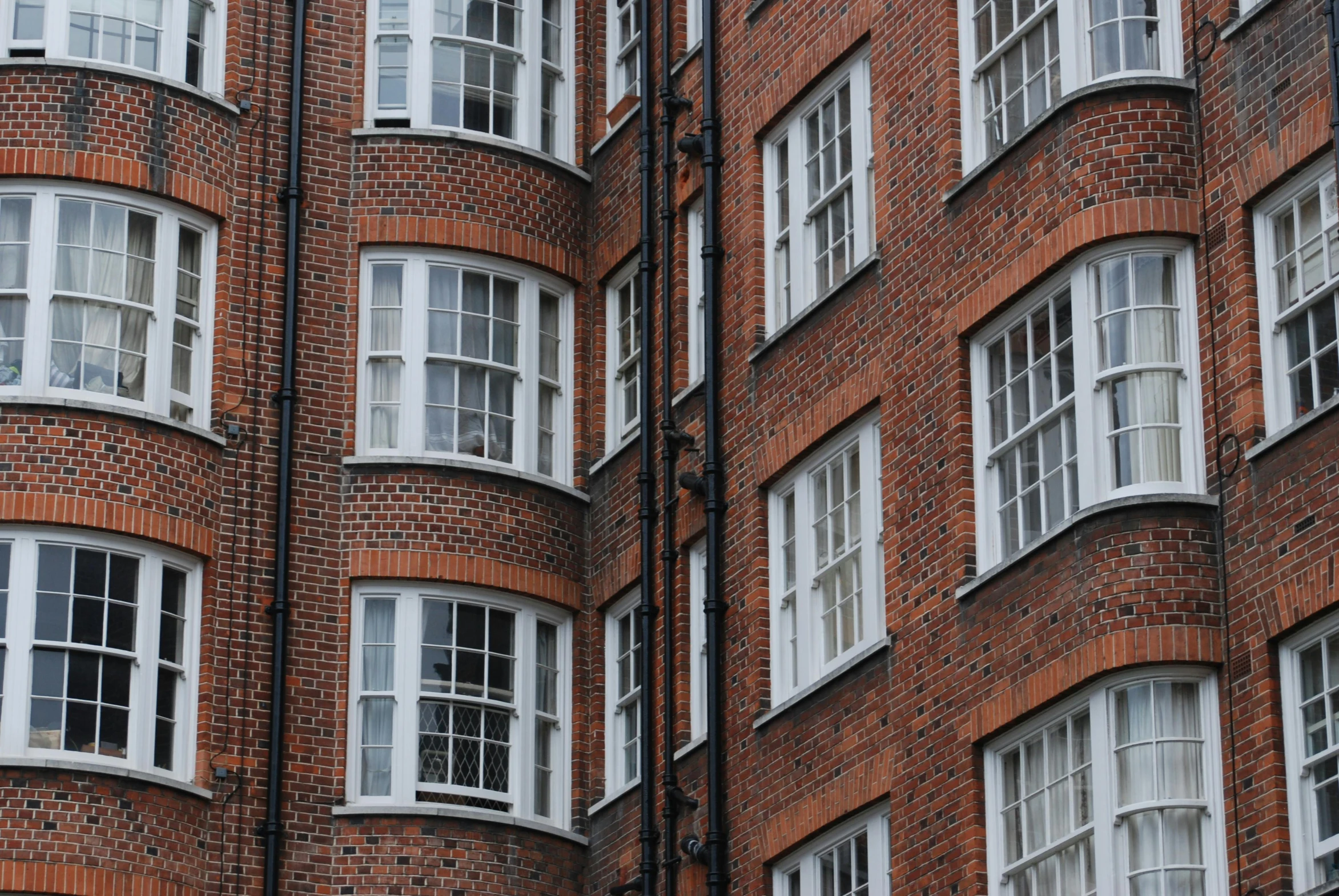 an apartment building with white windows and lots of red brick