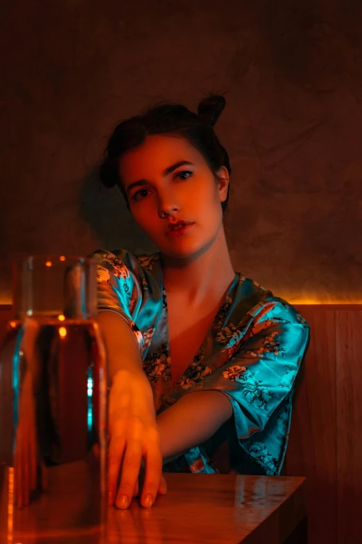 a woman sitting at a bar with a bottle of wine