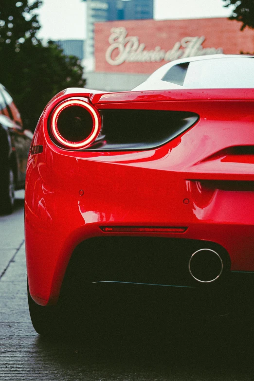 a red sports car with black rims parked near the street