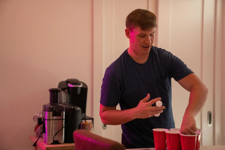 a man standing next to red cups near some food