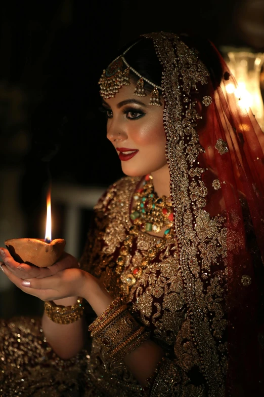 a woman in a red outfit holding a candle