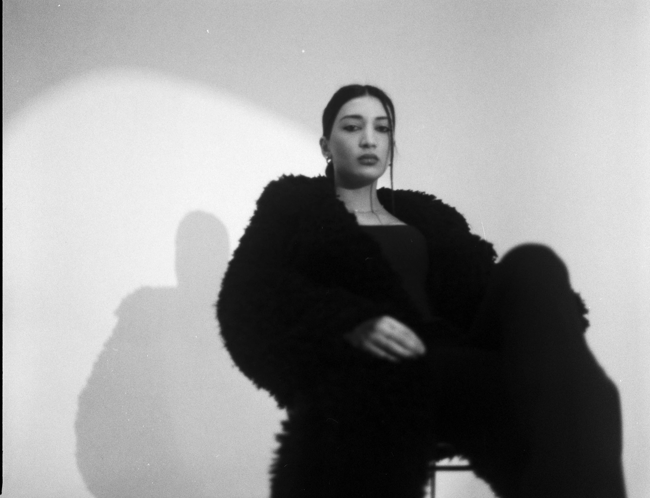 a woman posing in a black outfit and coat