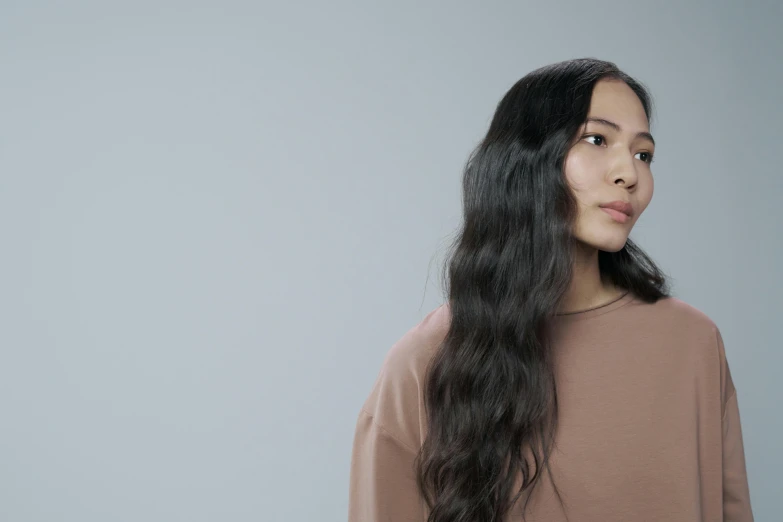 a woman standing in front of a gray background