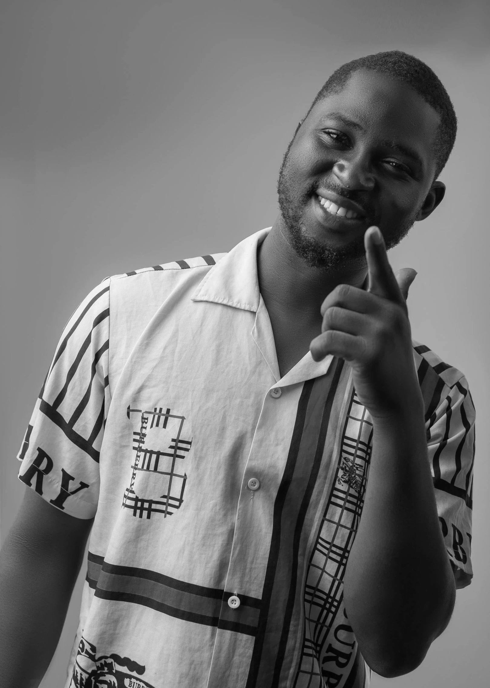 an african man in a white shirt pointing to the side