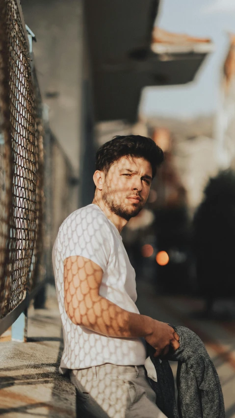 a young man with broken arm sitting on a ledge