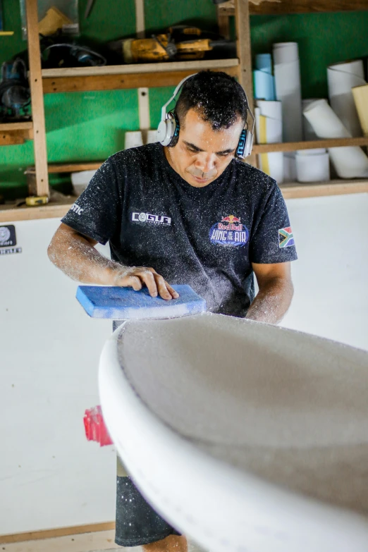 a man with headphones on putting soing in a bowl