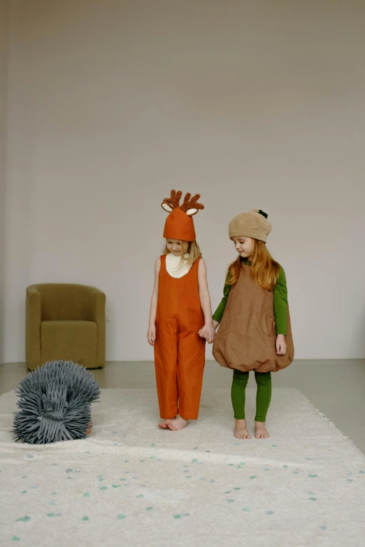 two little girls wearing reindeer costumes with a cat and bird