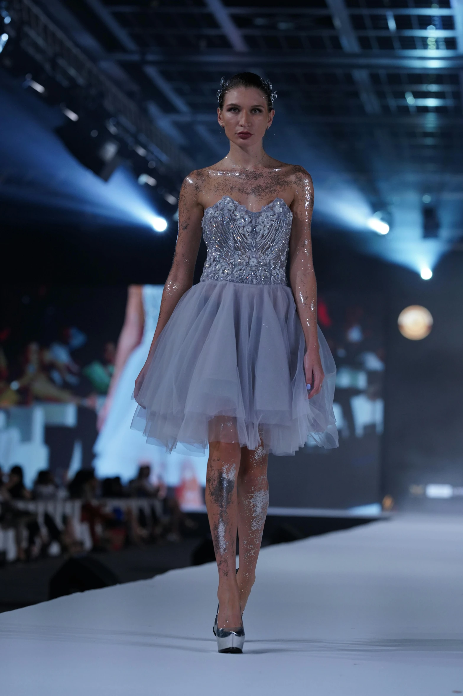 a model walking down a runway wearing a dress