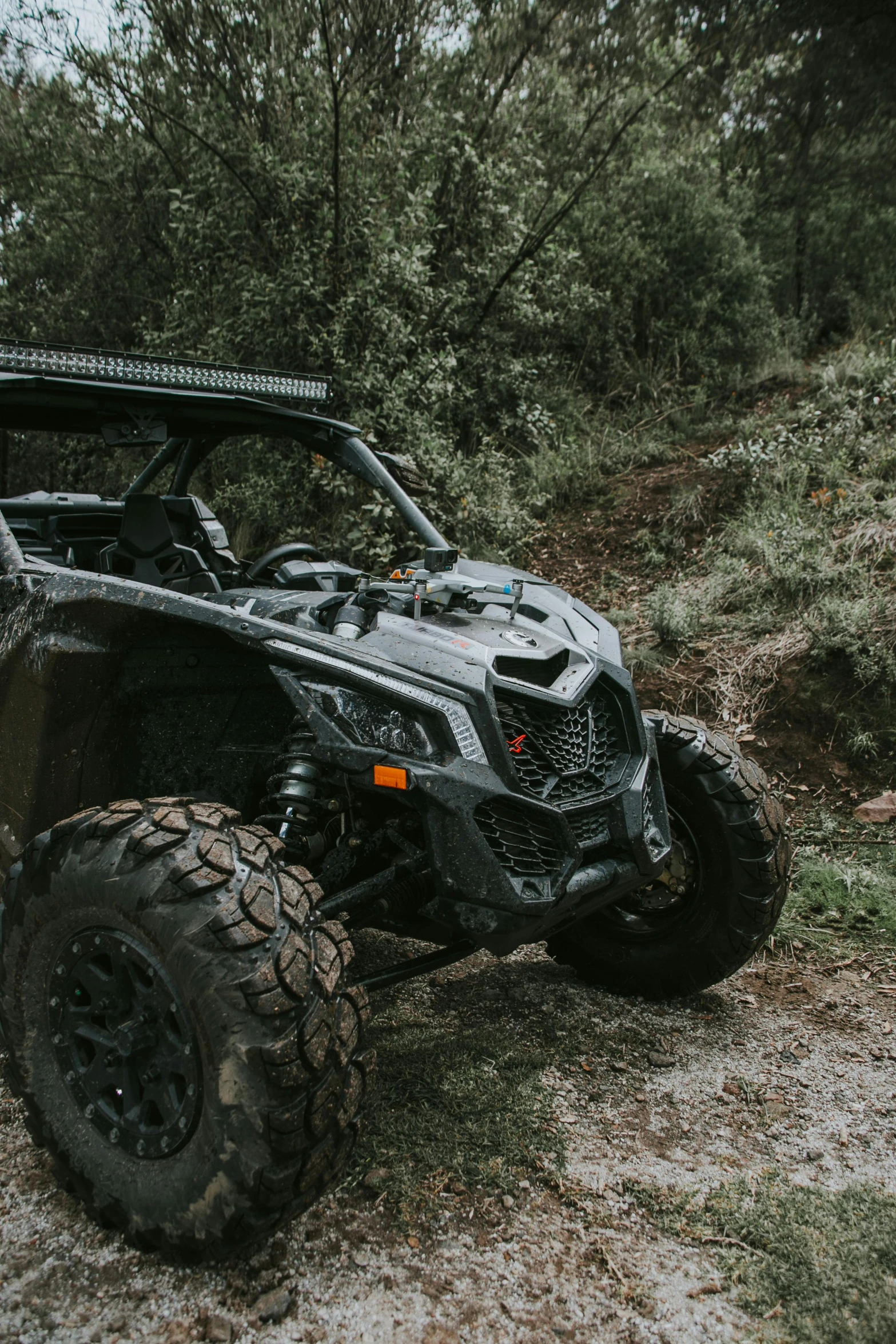 a black vehicle on some dirt near trees