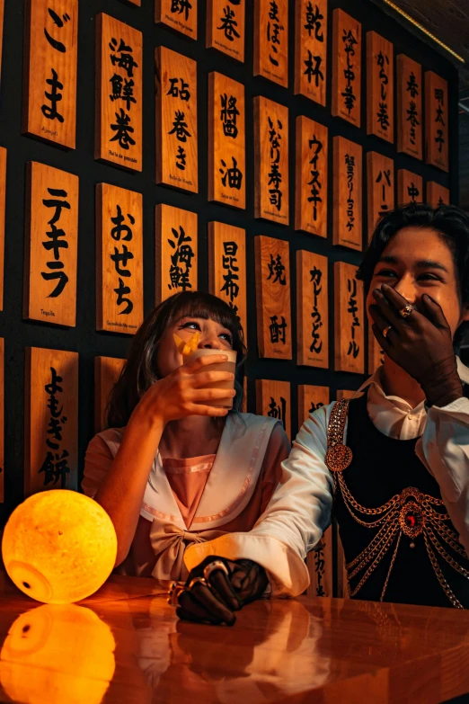 a couple posing for a picture while sitting at a restaurant