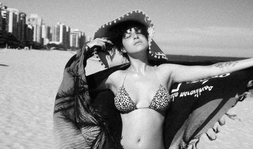 a woman wearing a bikini while posing on the beach