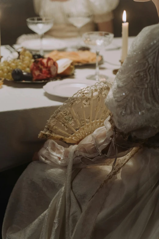 two women in dress are at a table with wine and candles