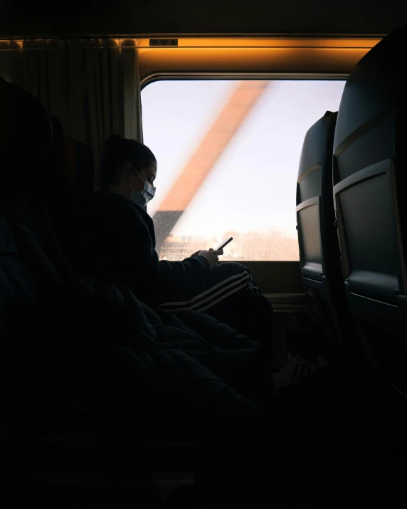 a person sitting on a seat looking at a cell phone