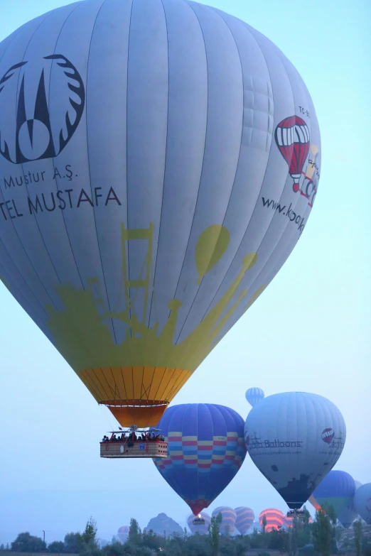 several  air balloons are being inflated on the ground