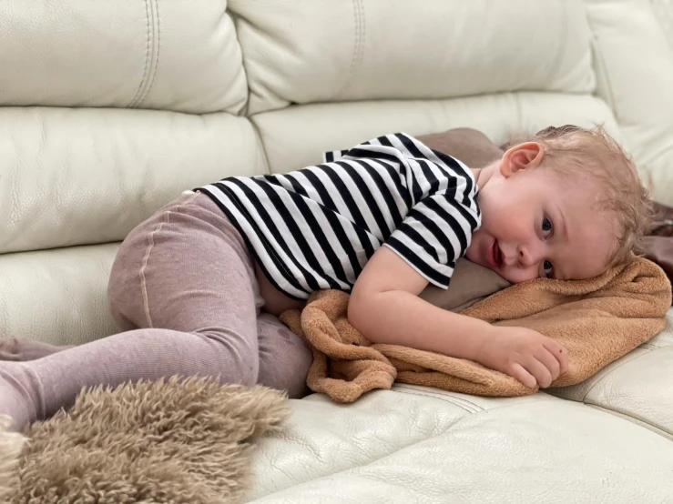 a child sleeping on a couch with a blanket