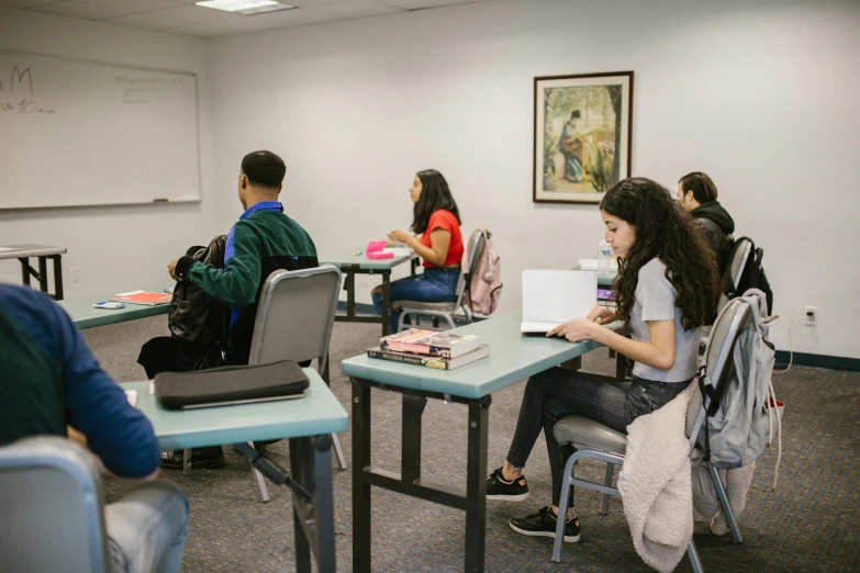 a group of young women sitting around a desk