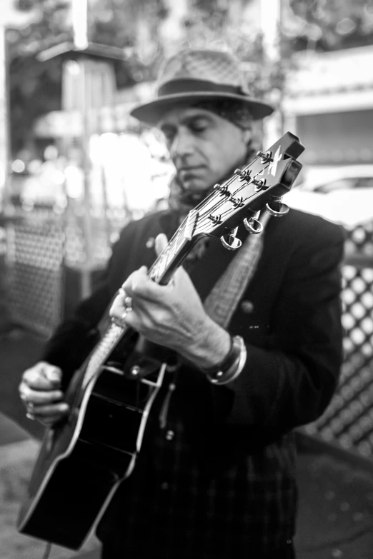 the man is playing an electric guitar on the sidewalk