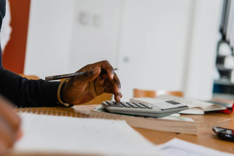 a person at a table with papers and a calculator