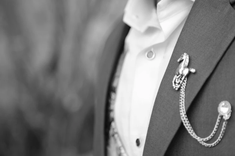 the grooms silver boutonniere has an interesting necklace