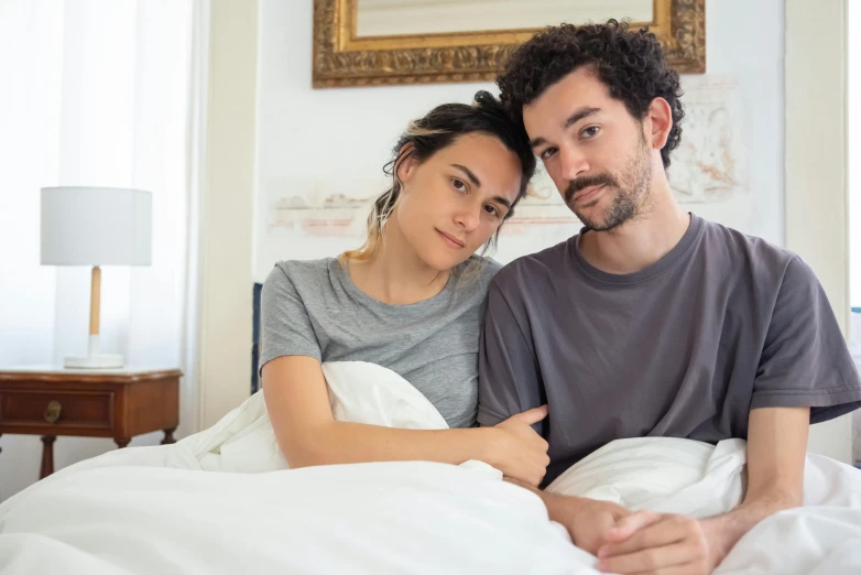 a man and woman are snuggled in bed together