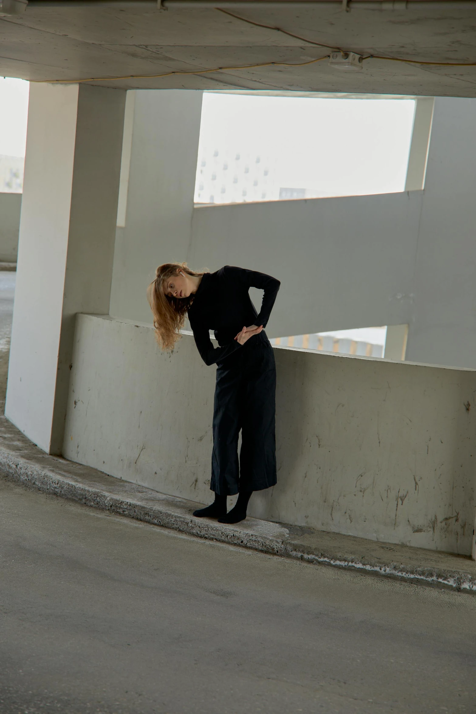 a woman leaning against a wall with her head in her hands