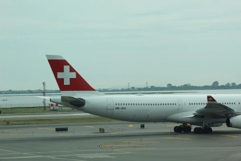 an airplane sitting on the runway next to water