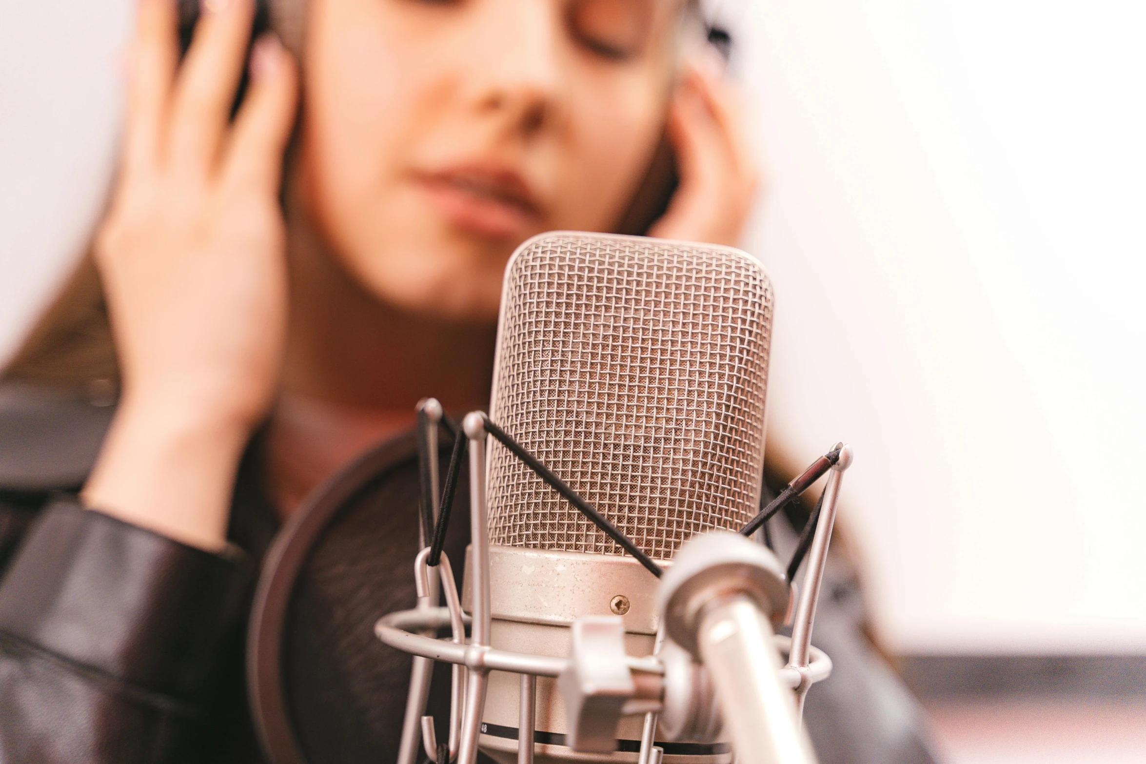 a woman wearing glasses is listening to an old fashioned microphone